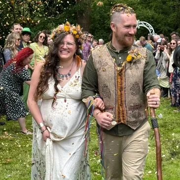 Guests throwing confetti at the happy couple during an outdoor ceremony