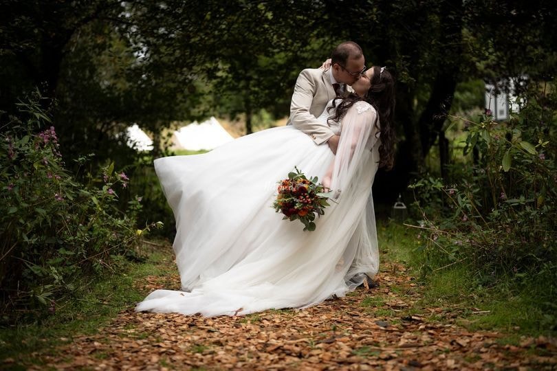 Bride and groom at outdoor wedding ceremony with garden arch at Oak Tree Farm